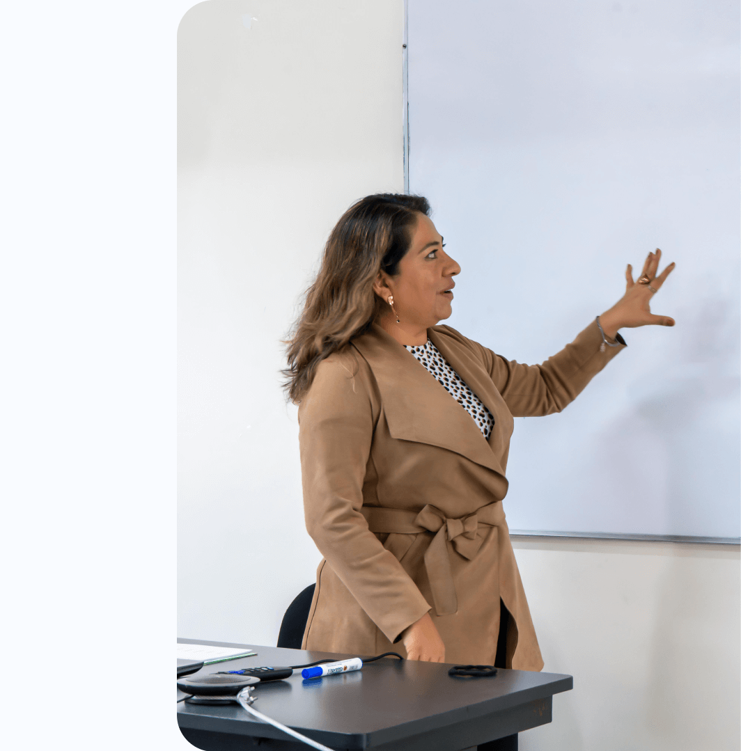 Maestra mostrando un tema en el pizarrón